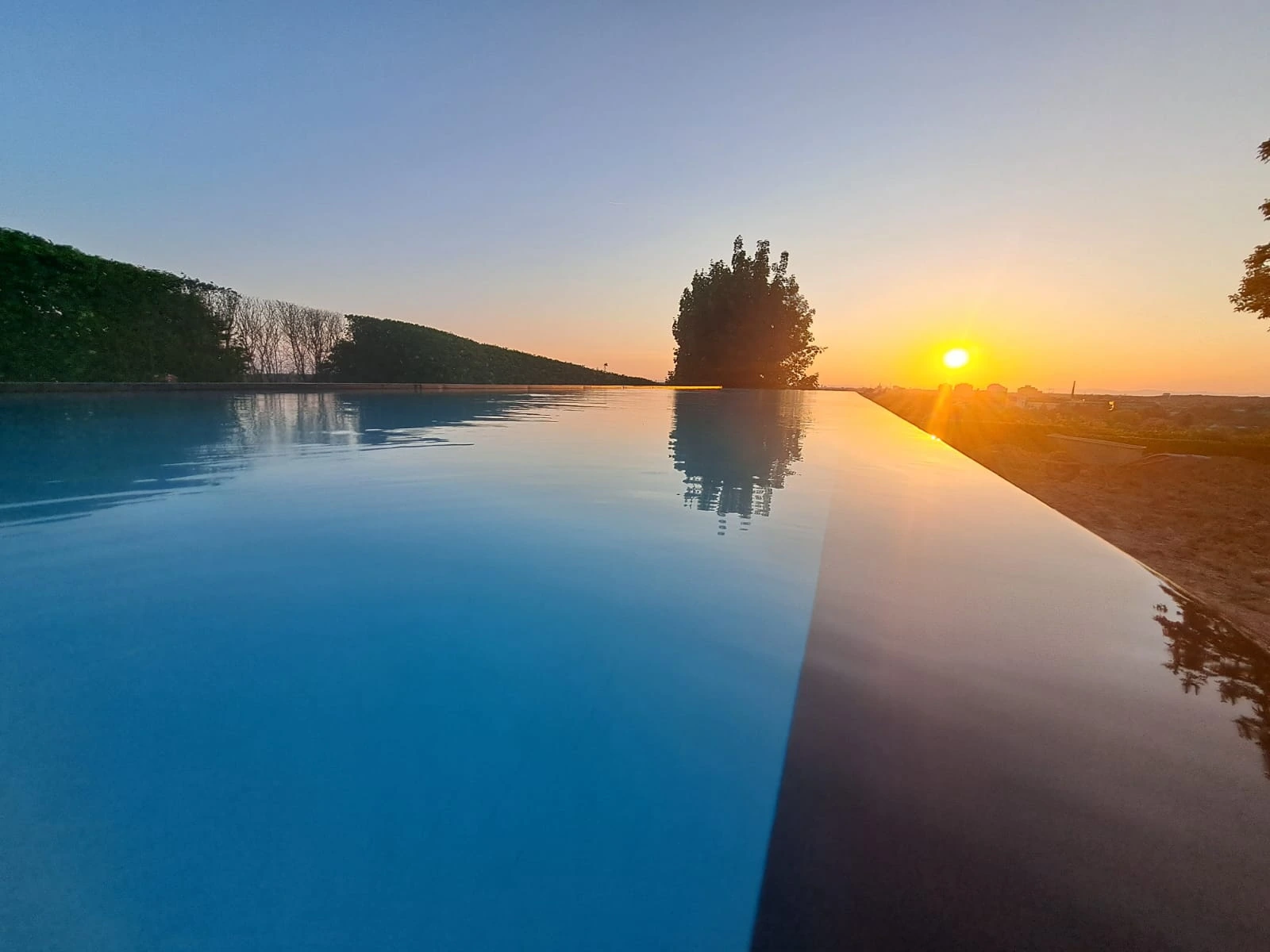 Overflow pool with an open view at sunset