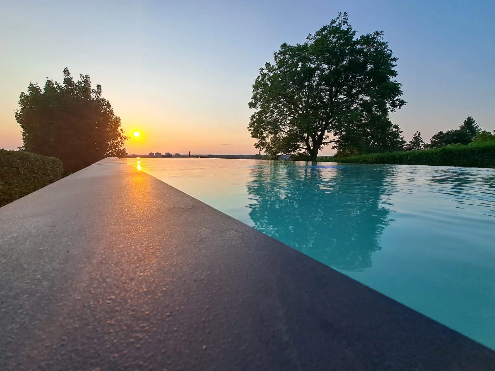Overflow pool with an open view at sunset