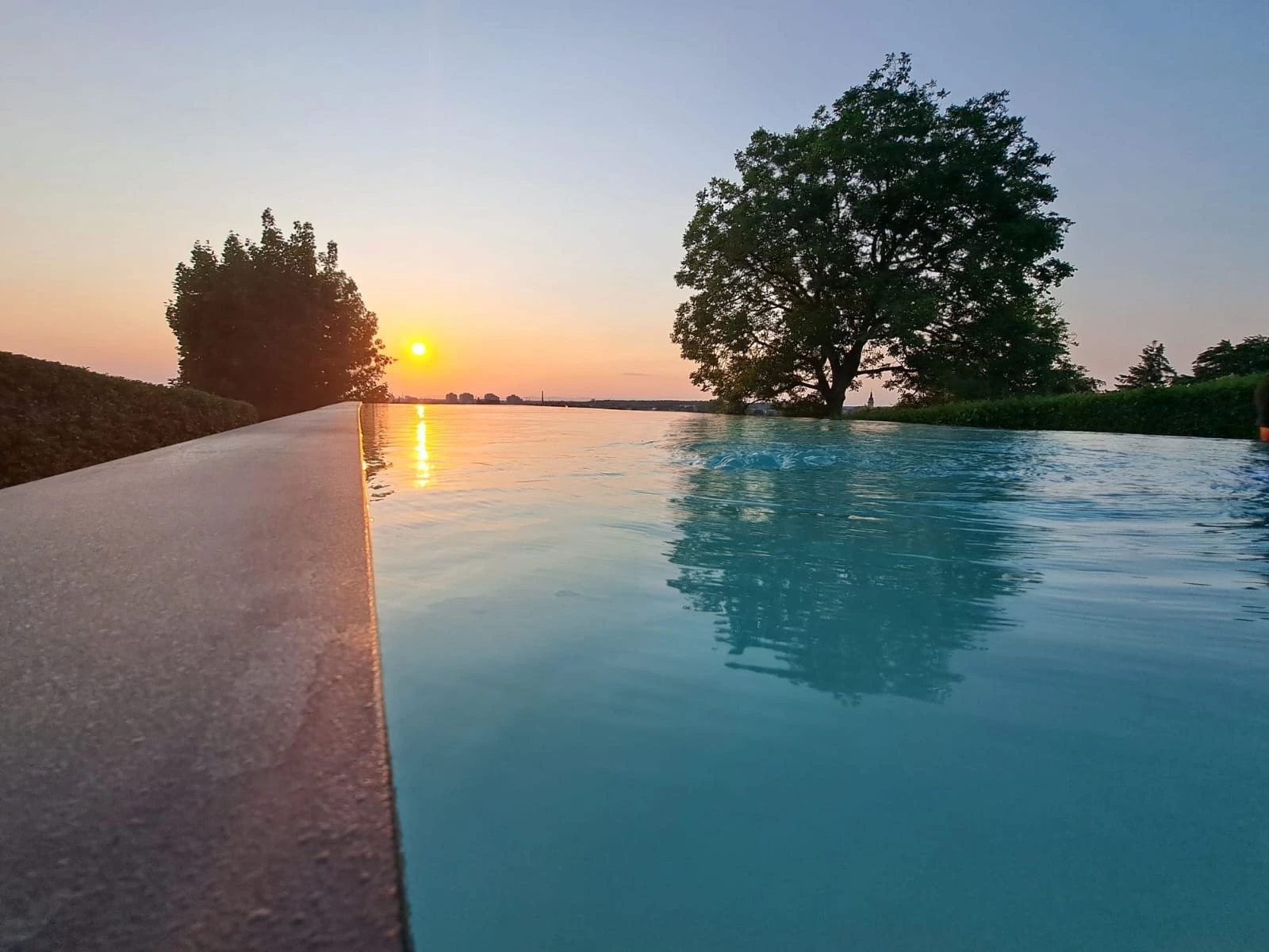 Overflow pool with an open view at sunset