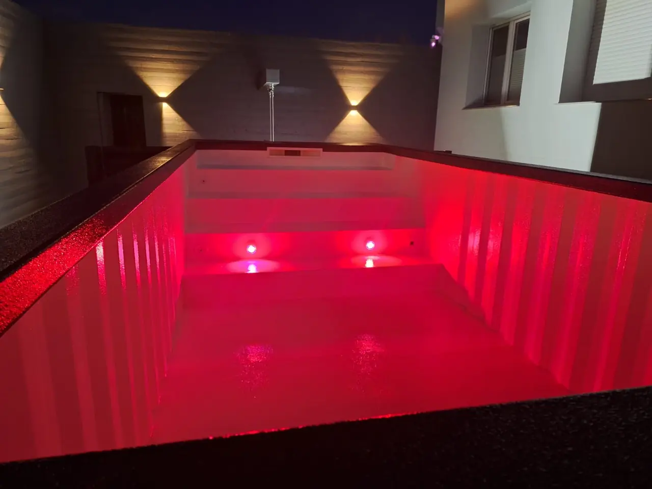 Rot beleuchtetes Poolbecken bei Nacht – No1Pool