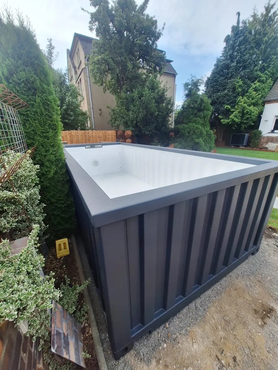 Außenansicht eines dunklen Poolmoduls im Garten – No1Pool