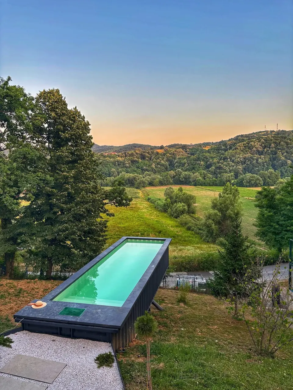 Pool oberhalb eines grünen Gartens in der Abendsonne – No1Pool