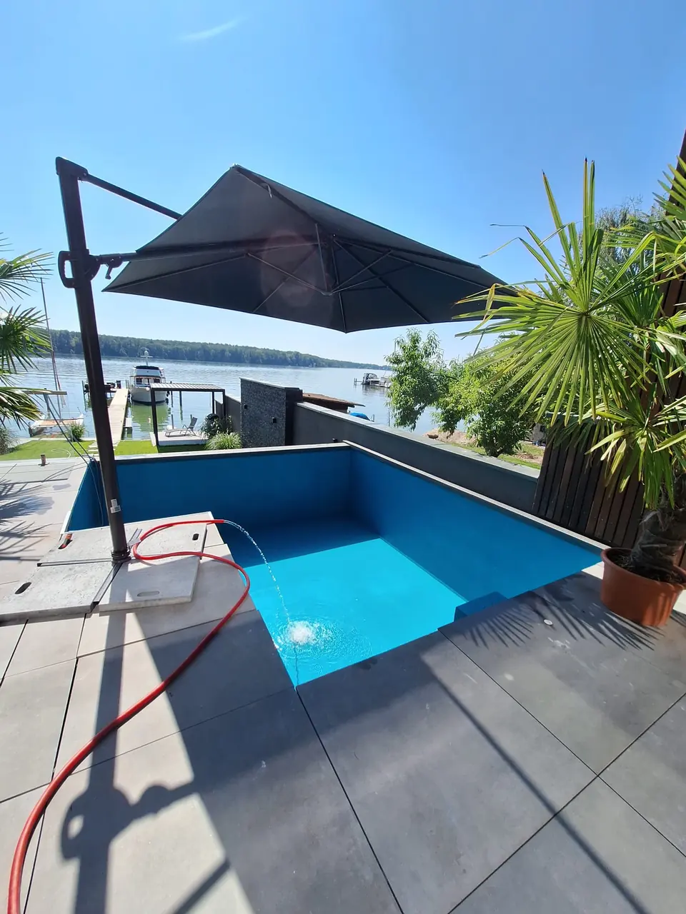 Poolanlage mit Sonnenschirm und Terrasse – No1Pool