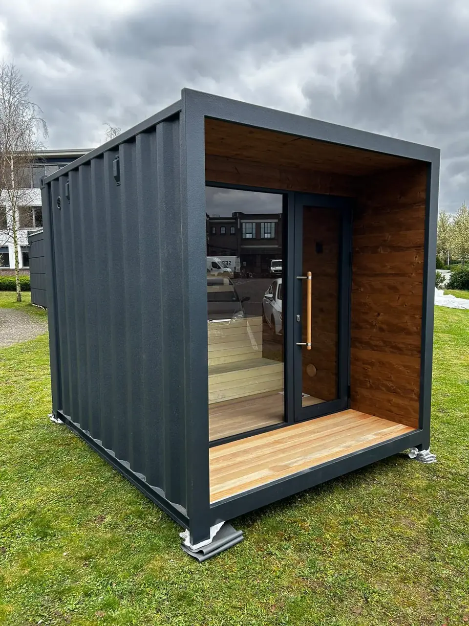 Container-Sauna mit warmer Holzverkleidung und Glasfront